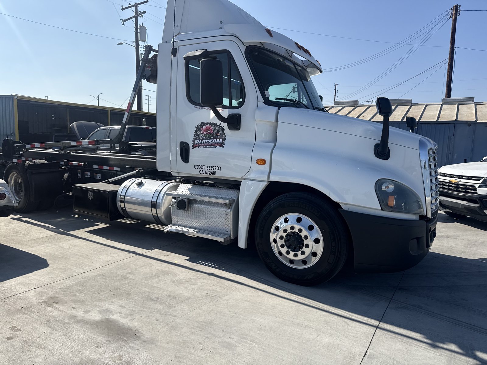 Blossom Roll Off Services roll-off truck in a commercial yard